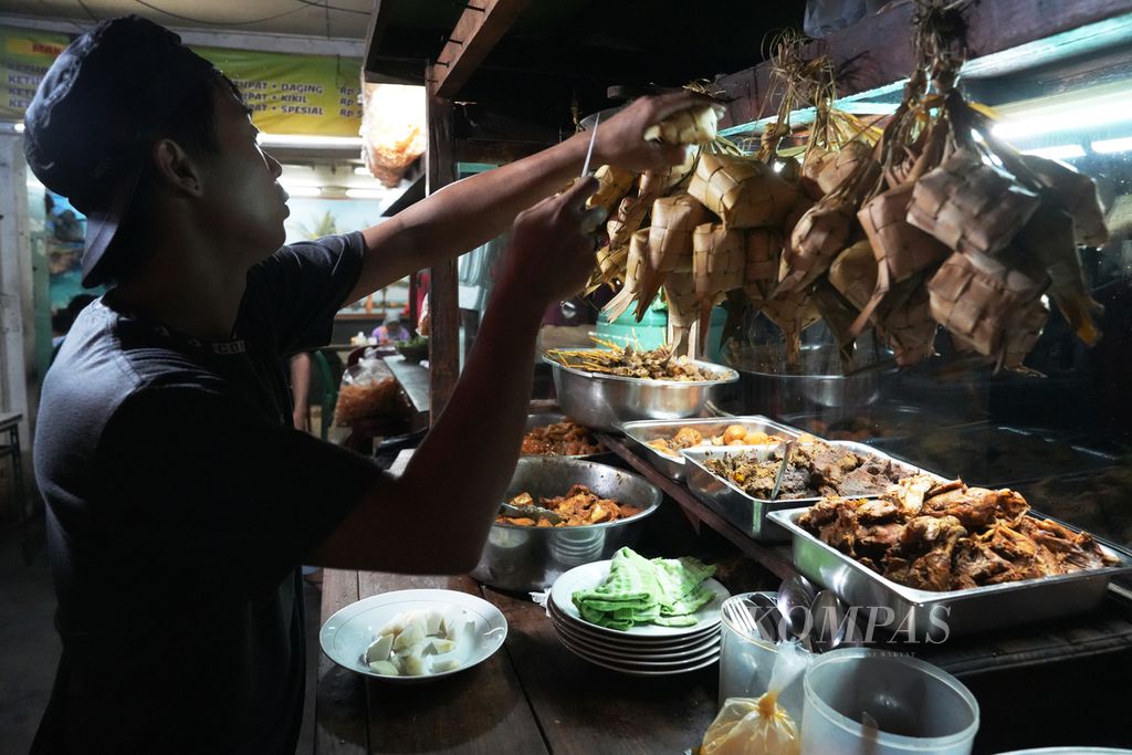 Penjual melayani pembeli Ketupat Sayur Mandala di Jalan Mampang Prapatan, Jakarta Selatan, Rabu (13/11/2024). Warung ketupat sayur tersebut buka dari pukul 18.00 WIB hingga pukul 04.00 WIB. Dalam sehari sebanyak 600-700 porsi habis terjual. Ada enam pilihan menu ketupat sayur di warung tersebut.
