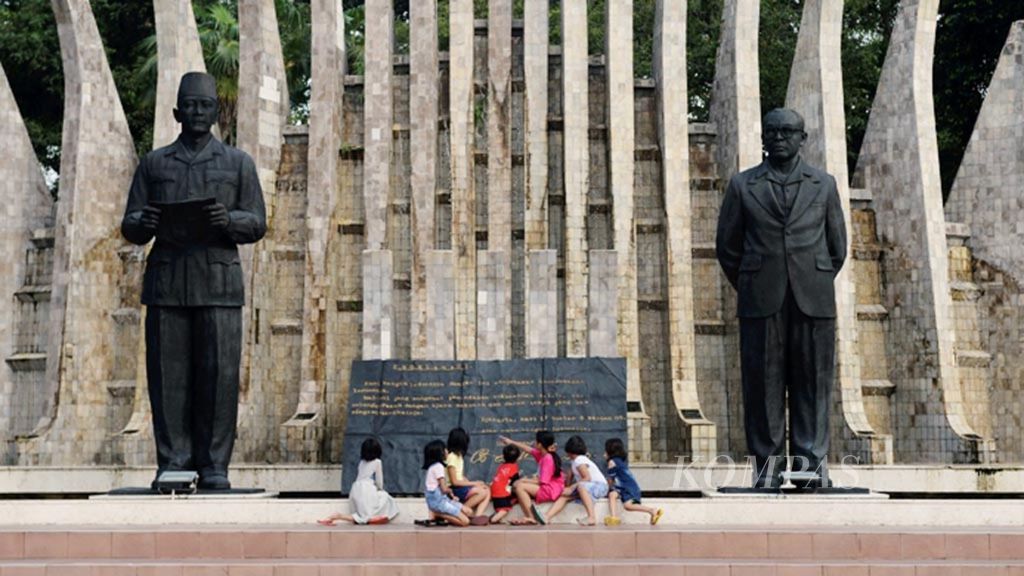 Anak-anak membaca naskah proklamasi yang ditulis di atas batu marmer di Tugu Proklamasi, Jakarta, Rabu (21/2/2018).  
