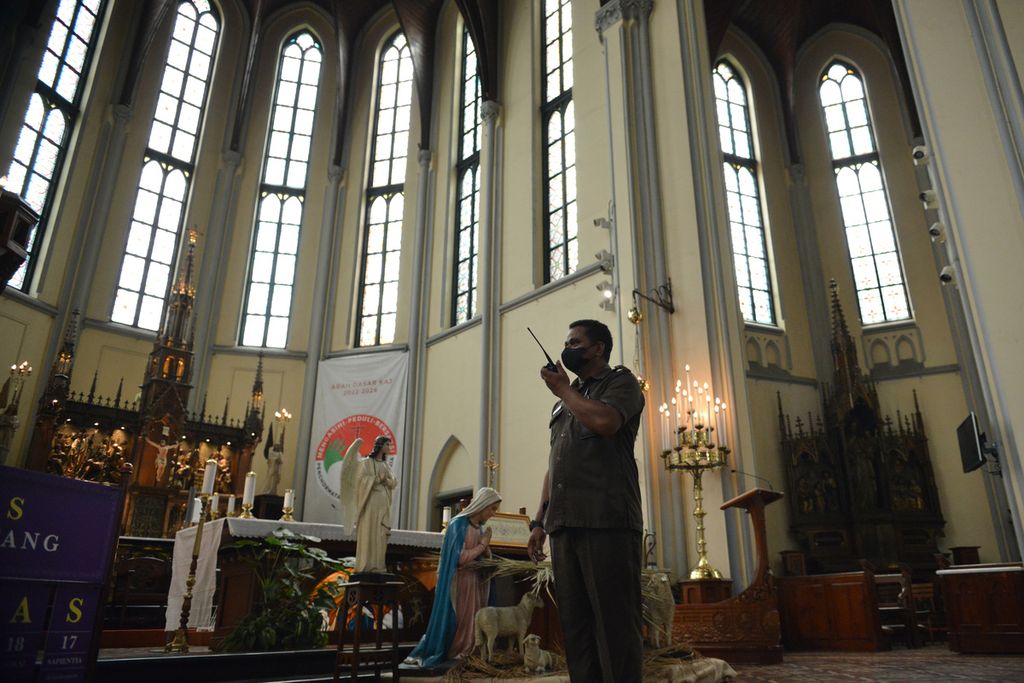 Petugas keamanan gereja melintas di depan altar Gereja Katedral Jakarta atau Gereja Santa Maria Diangkat Ke Surga, Jakarta Pusat, Jumat (23/12/2022). Menjelang ibadah Natal 2022 sejumlah persiapan untuk melakukan peribadatan secara luring disiapkan para pengurus Gereja Katedral Jakarta. (Z19)