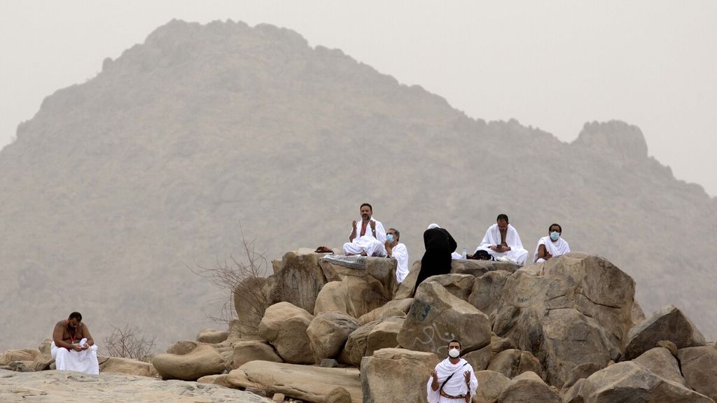 Jemaah haji memanjatkan doa di dekat bukit berbatu Jabal al-Rahma atau Gunung Belaskasih, di Padang Arafah, sebelah timur Kota Suci Makkah, Arab Saudi, Senin (19/7/2021). Para jemaah haji berkumpul di Padang Arafah untuk melaksanakan wukuf yang menjadi puncak ritual ibadah haji. Wukuf berasal dari kata Arab wuquf yang berarti berhenti. Ini dimaknai sebagai ajakan kepada manusia agar meninggalkan semua aktivitas dunia selama beberapa jam untuk melakukan tafakur atau perenungan diri.