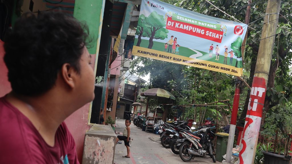 Seorang warga merokok di Kampung Tanpa Rokok Penas Tanggul di Kelurahan Cipinang Besar Selatan, Kecamatan Jatinegara, Jakarta Timur, Selasa (24/10/2023) siang.