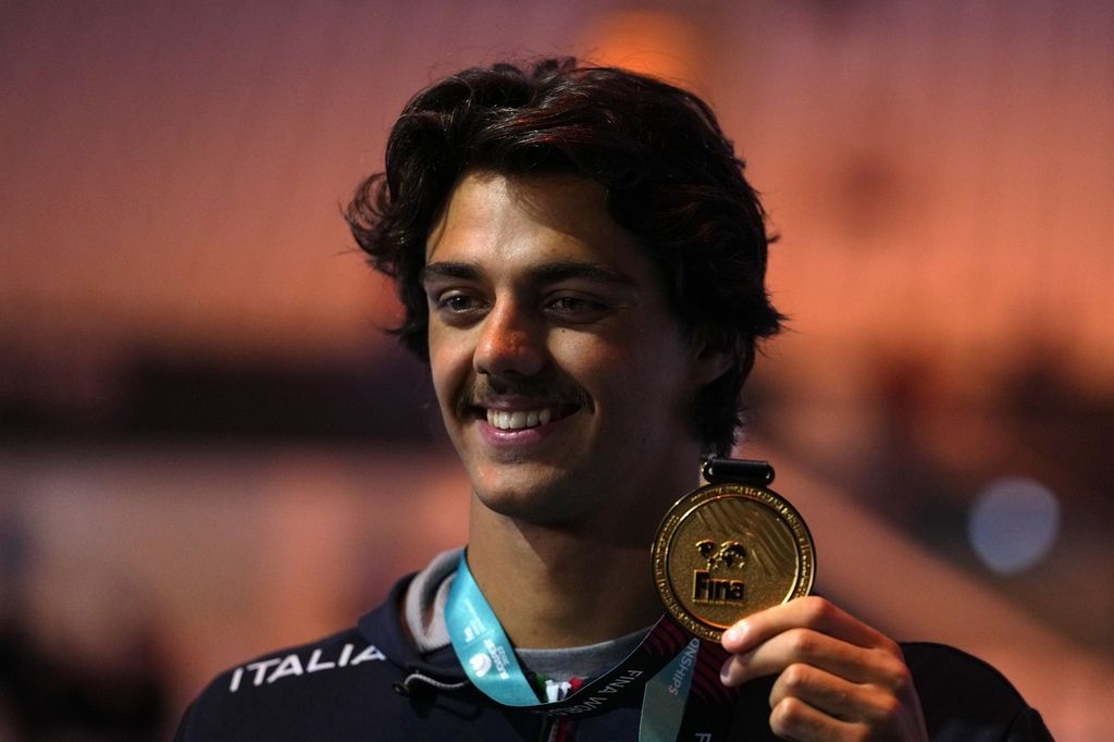Perenang Italia, Thomas Ceccon, memamerkan medali emasnya setelah memenangi nomor 100 meter gaya punggung pada Kejuaraan Dunia Renang di Budapest, Hongaria, Senin (20/6/2022). Ceccon juga memecahkan rekor dunia dengan mencatat waktu 51,60 detik, 