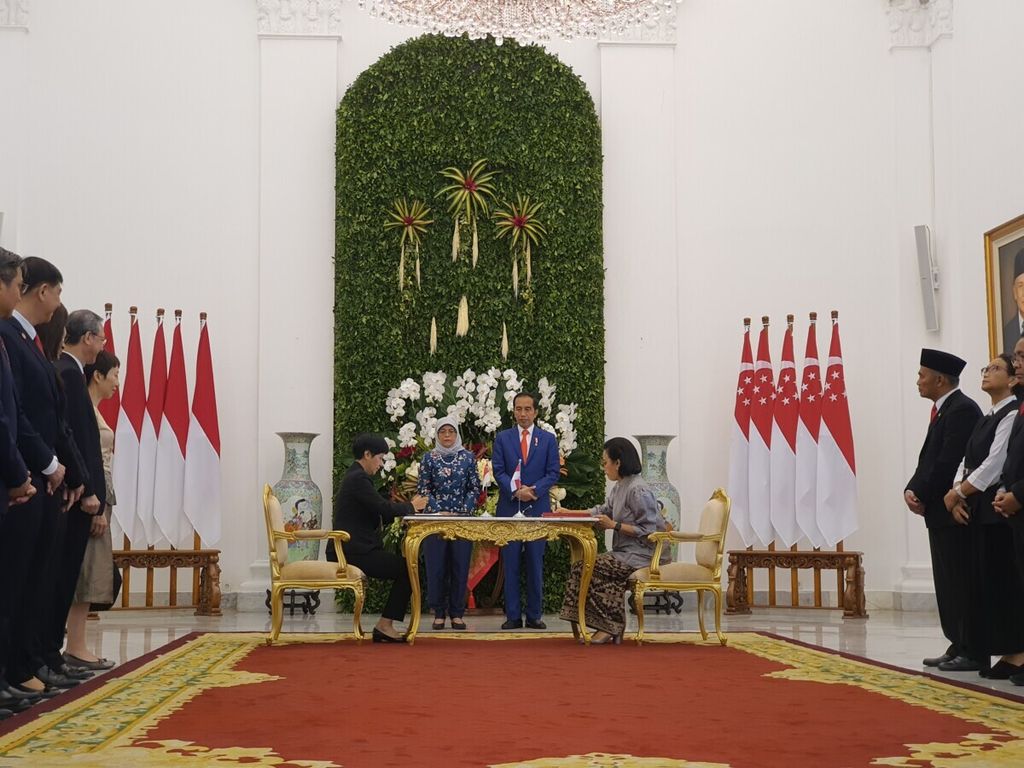 Presiden Joko Widodo dan Presiden Singapura Nyonya Halimah Yacob menyaksikan penandatanganan nota kesepahaman penghindaran pajak berganda antara Menteri Keuangan Sri Mulyani Indrawati (kanan) dan Menteri Keuangan Kedua Singapura Indranee Rajah. Penandatanganan dilakukan di akhir kunjungan kenegaraan Presiden Singapura ke Indonesia di Ruang Teratai Istana Kepresidenan Bogor, Selasa (4/2/2020).