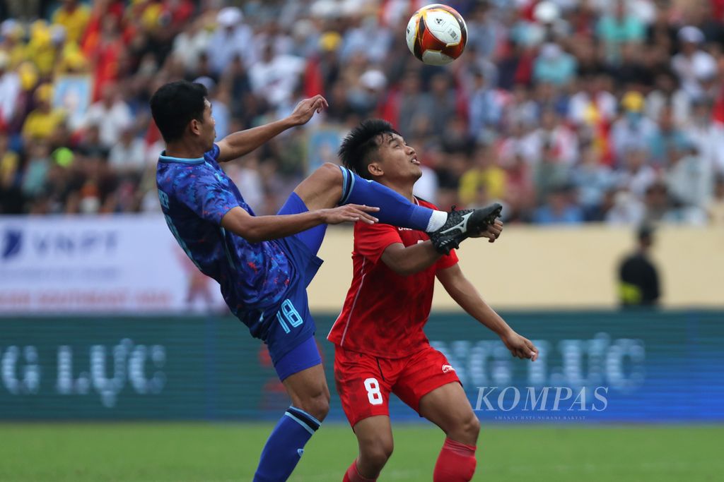 Gelandang timnas Indonesia, Witan Sulaeman (kanan), berebut bola dengan gelandang timnas Thailand, Weerathep Pomphun (kiri), dalam babak semifinal cabang sepak bola SEA Games Vietnam 2021 di Stadion Thien Truong, Nam Dinh, Vietnam, Kamis (19/5/2021).  
