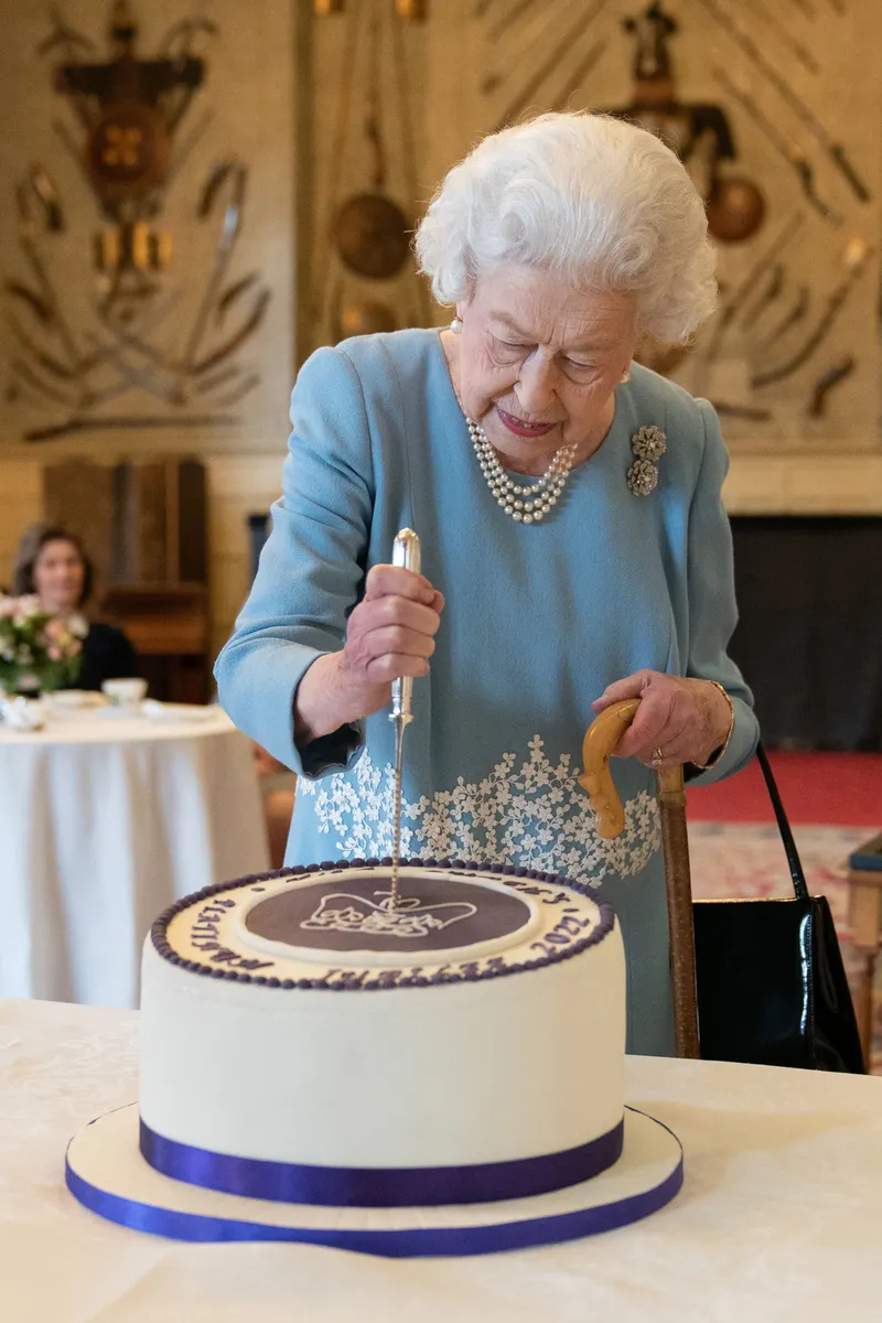 Ratu Elizabeth II memotong kue untuk menandai dimulainya perayaan Platinum Jubilee dalam acara resepsi di Ballroom Istana Sandringham, kediaman Ratu di Norfolk, 5 Februari 2022. 