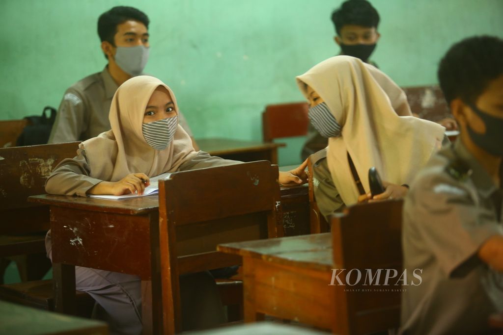 Siswa-siswi kelas X mengikuti pelajaran dengan tetap mengenakan masker ketika berlangsung sekolah tatap muka di SMA Negeri 1 Giri Banyuwangi, Senin (16/11/2020). Saat itu sebanyak 7.861 siswa dari total 36.444 siswa SMA/SMK sederajat di Banyuwangi mengikuti uji coba sekolah tatap muka tahap kedua.