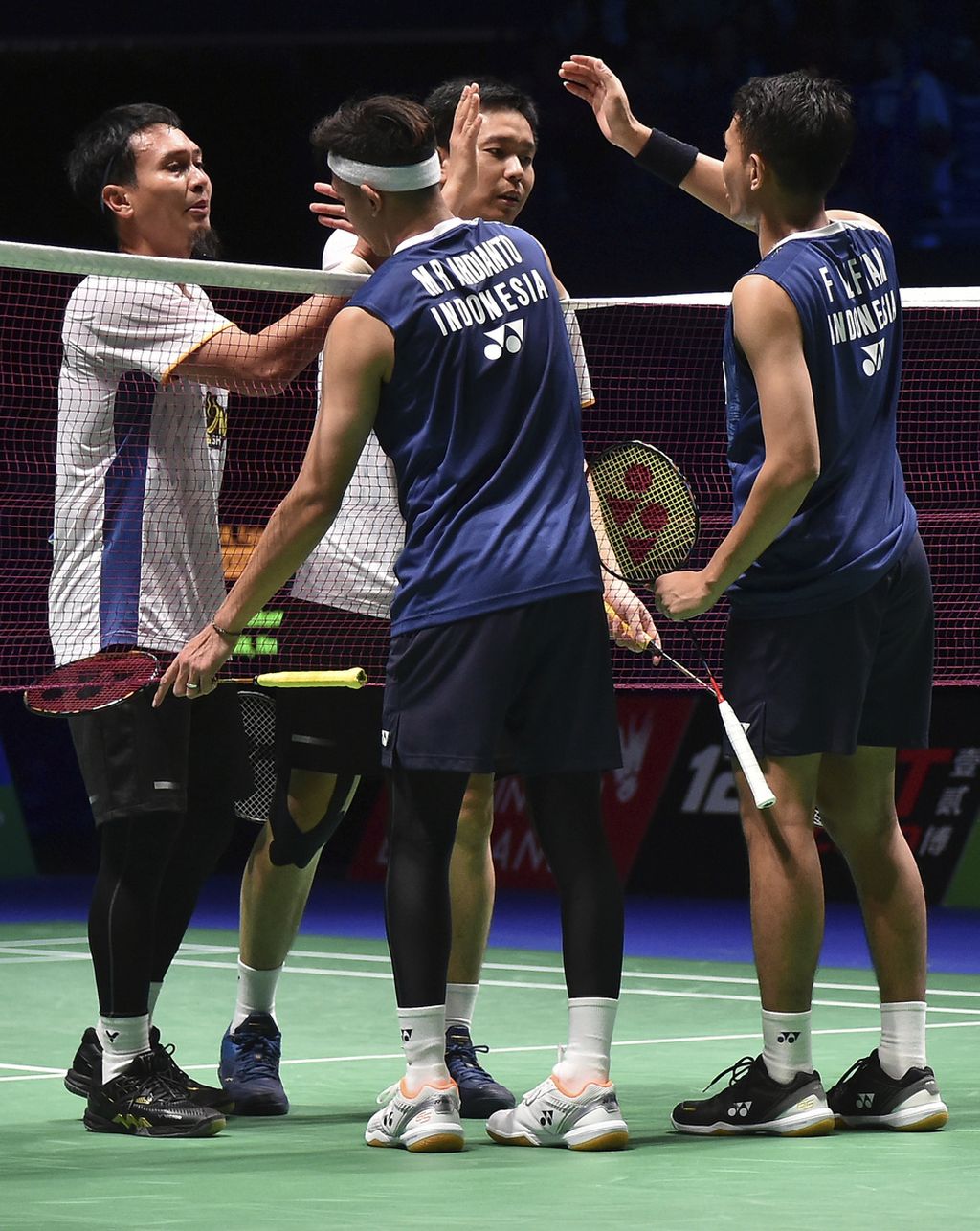 Ganda putra Fajar Alfian/M Rian Ardianto (membelakangi lensa), bersalaman dengan rekan senegaranya, Mohammad Ahsan dan Hendra Setiawan, seusai laga final ganda putra All England 2023 di Birmingham, Inggris, Minggu (19/3/2023). 