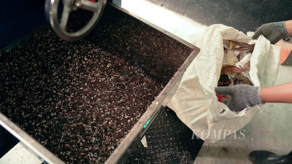 Pekerja mengecek hasil mesin cacah dalam peluncuran pengelolaan sampah mandiri di ITC Cempaka Mas, Jakarta Pusat, Kamis (23/6/2022). Produk setara batubara muda (<i>refused derived fuel</i>/RDF) yang dihasilkan dari mesin cacah tersebut dikirim ke pabrik Indocement untuk dijadikan bahan bakar pengganti batubara.