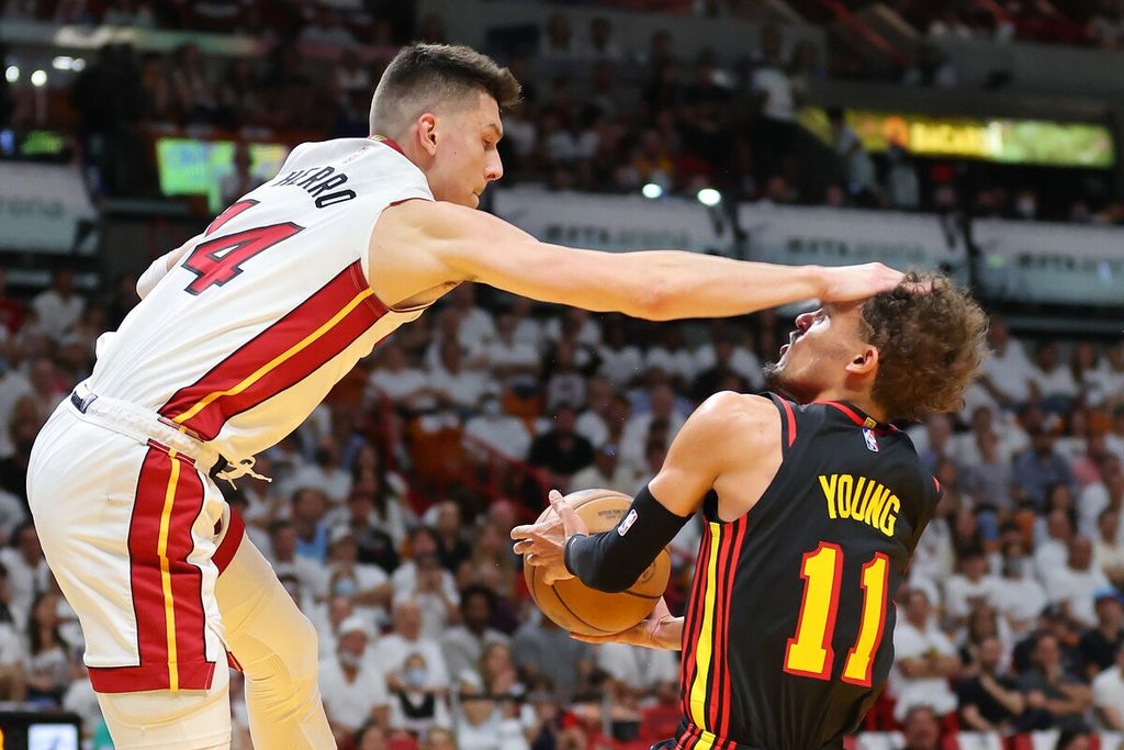 Pemain Miami Heat, Tyler Herro (kiri), melakukan pelanggaran terhadap pemain Atlanta Hawks, Trae Young, pada laga pertama babak <i>playoff </i>di FTX Arena, Miami, Florida, Amerika Serikat, Senin (18/4/2022) WIB. Pada laga itu, Heat menang dengan skor 115-91.