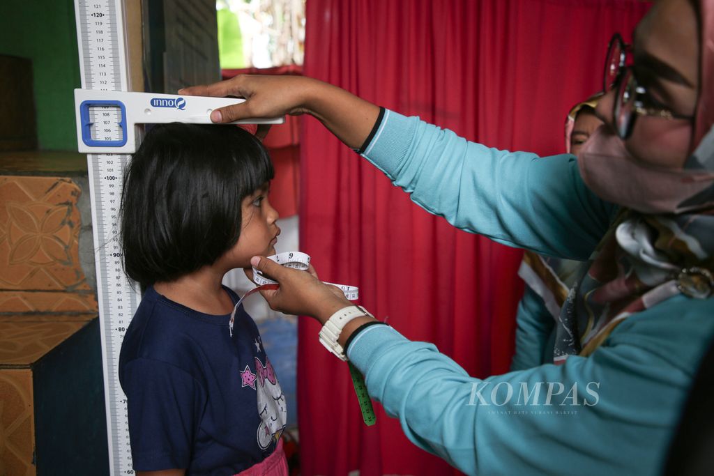 Petugas posyandu mengukur tinggi seorang anak dalam kegiatan pemeriksaan rutin bulanan di Posyandu Kecipir, Larangan Utara, Larangan, Kota Tangerang, Banten, Kamis, 13 Juni 2024.