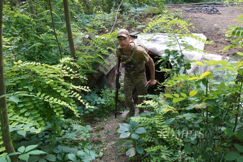 Seorang tentara Ukraina keluar dari dalam parit di salah satu lokasi di sekitar garis depan pertempuran di wilayah timur Ukraina, Jumat (8/7/2022). Perang Ukraina-Rusia di garis depan lebih banyak diwarnai dengan pertempuran artileri dan serangan udara. Para prajurit menggunakan parit untuk berlindung dari serangan artileri. 