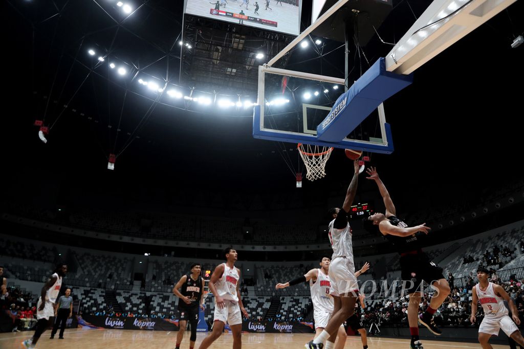 Pemain Indonesia Patriots, Antoni Erga (hitam), melakukan <i>lay up</i> pada laga pertama Invitasi Bola Basket Internasional Indonesia (IIBI) di Stadion Indonesia Arena, Jakarta, Rabu (2/8/2023). Timnas menang atas Indonesia Patriots, 82-56. IBII menjadi ajang mengukur kualitas tim nasional saat ini serta memastikan kelayakan dan fungsi Indonesia Arena. 