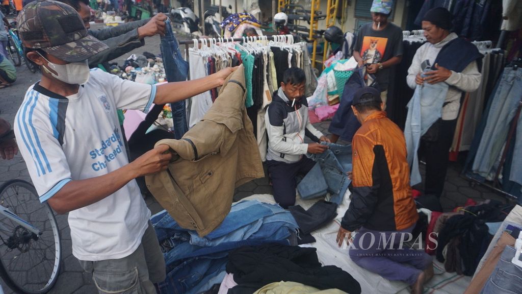 Para pengunjung memilih-milih pakaian impor bekas, di Pasar Notoharjo, Kota Surakarta, Selasa (7/6/2022). Pasar tersebut menajdi pusatnya perburuan pakaian bekas. Lapak pakaian bekas digandrungi karena harganya yang cenderung miring. Di sisi lain, kerap ditemukan barang-barang berkualitas dan bermerek internasional. Belakangan, budaya berburu pakaian bekas disebut thrifting. Budaya itu tengah marak bagi kalangan anak-anak muda di Kota Surakarta.