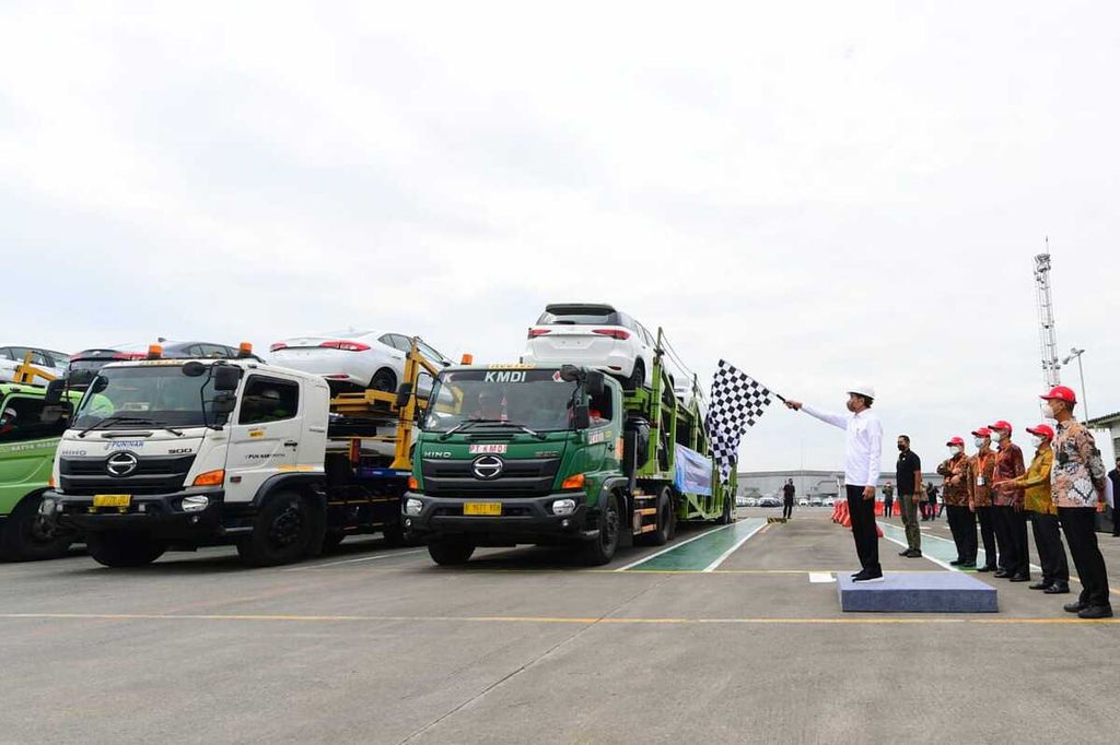 Presiden Joko Widodo melambaikan bendera berpola kotak-kotak warna putih dan hitam menandai pelepasan unit kedua juta ekspor mobil utuh ke mancanegara dan ekspor perdana Fortuner ke Australia oleh PT Toyota Motor Manufacturing Indonesia di Kabupaten Karawang, Jawa Barat, Selasa (15/2/2022).
