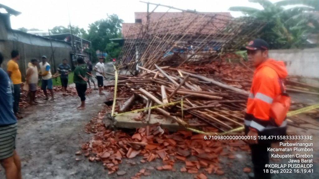 Petugas mengecek bangunan yang rusak setelah hujan deras dan angin kencang di Kecamatan Plumbon, Kabupaten Cirebon, Jawa Barat, Minggu (18/12/2022).