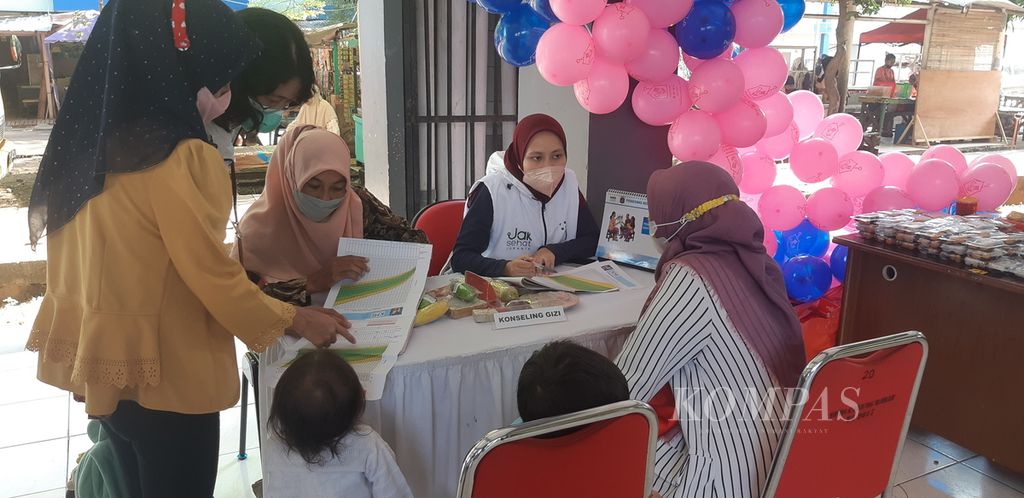 Warga mengonsultasikan gizi anak dengan petugas puskesmas di Rusun Albo, Cakung Barat, Jakarta Timur, Selasa (21/3/2023).