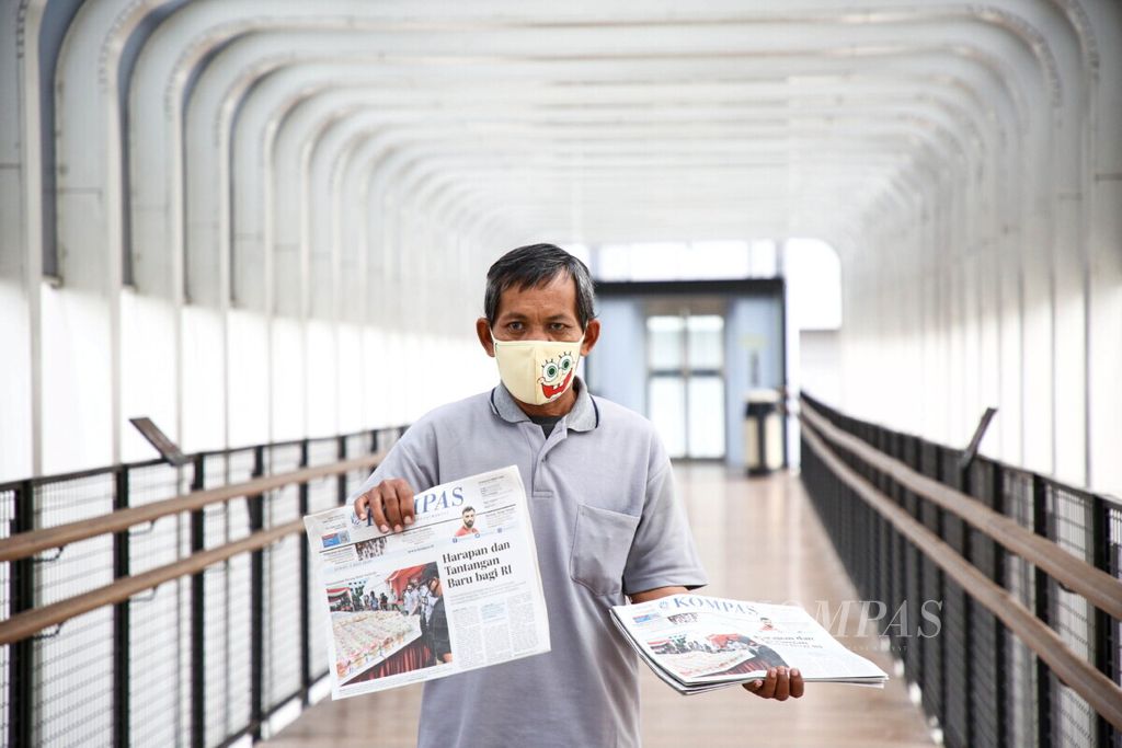 Mustawan loper koran Kompas yang selalu menawarkan koran <i>Kompas </i>di jembatan penyeberangan orang Ratu Plaza, Jakarta Pusat, seperti terlihat pada hari Jumat (3/7/2020). Penumpang bus Transjakarta yang sebagian besar adalah pekerja kantoran di kawasan Senayan adalah salah satu pelanggan potensialnya. 