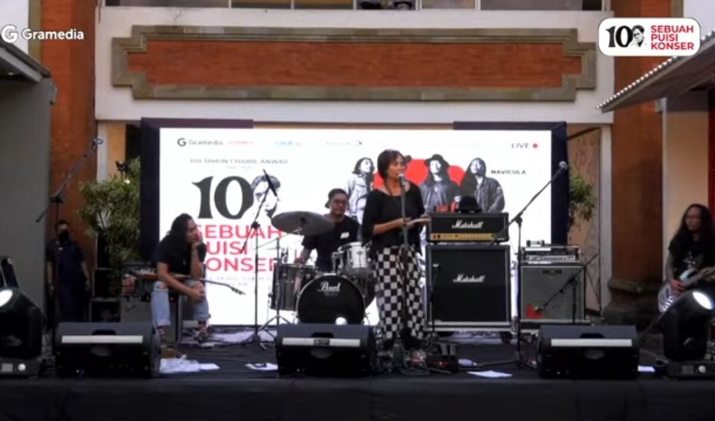 Tangkapan layar dari tayangan acara bertajuk 100 Membaca Chairil serangkaian pembukaan kembali (<i>reopening</i>) toko buku Gramedia Bali Mal Galeria di Mal Bali Galeria, Kuta, Kabupaten Badung, Sabtu (16/7/2022). Sastrawan Bali Oka Rusmini (berdiri) tampil membacakan puisi berjudul "Sajak Putih" karya Chairil Anwar. 