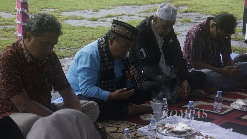 Raja Bashar Alimuddin Latar (berpeci putih) berdoa bersama Direktur Jenderal Kebudayaan Kemendikbudristek Hilmar Farid (paling kiri) dipimpin oleh pemuka adat setempat (berpeci hitam berbaju biru), Senin (20/6/2022) pagi. Orang Banda Eli, yaitu orang-orang Banda yang melarikan diri keluar Banda sejak 401 tahun silam, diundang untuk mengunjungi kampung halaman leluhur mereka. Di Benteng Nassau, Banda Neira, mereka mendoakan arwah para leluhur Banda yang dibantai VOC pada 1621 karena menolak usaha monopoli perdagangan pala dan rempah-rempah di Kepulauan Banda.