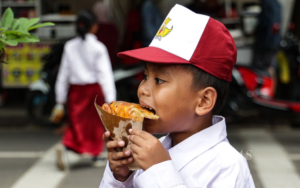 A student at Joglo 01 Public Elementary School, Kembangan, West Jakarta, enjoying snacks while waiting to be picked up, Monday (1/30/2023). From 10 million to 22 million people in Indonesia have diarrhea due to contaminated food and water.